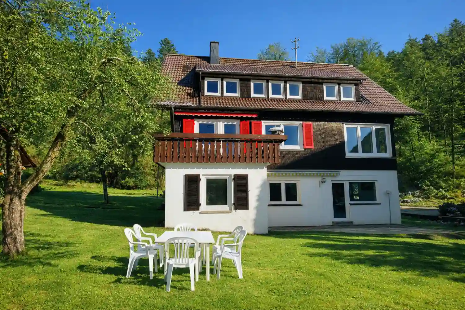 Hausfront von Tanne und Tal Relax im Sommer mit großer Rasenfläche, Sitzgruppe im Garten und sonniger Lage im Schwarzwald