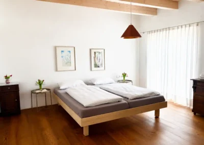 Schlafzimmer im Ferienhaus Baiersbronn Weitblick mit Doppelbett und Holzboden