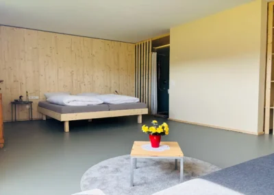 Schlafzimmer mit Doppelbett und Wohnbereich im Ferienhaus Baiersbronn Weitblick