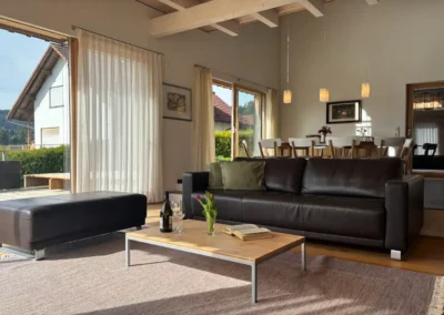 Wohnzimmer im Ferienhaus Baiersbronn Weitblick mit Sofa und angrenzendem Essbereich