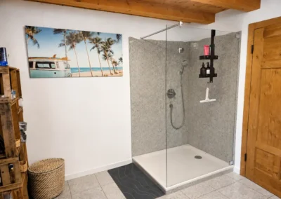 Großes Badezimmer mit begehbarer Dusche und Holzdetails im Refugium am Ursprung