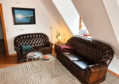 Gemütliche Lounge-Ecke mit Ledersofas im Dachgeschoss des Refugium am Ursprung