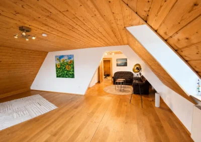 Großer Dachgeschossraum mit Holzdecke und Sitzecke im Refugium am Ursprung