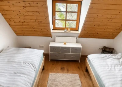 Dachzimmer mit zwei Einzelbetten und Holzverkleidung im Refugium am Ursprung - für eine Auszeit im Schwarzwald