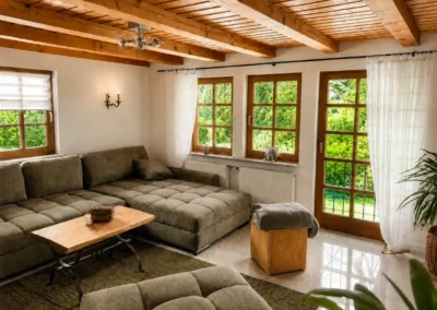 Wohnzimmer mit großem Sofa, Holzbalkendecke und Gartenzugang im Refugium am Ursprung - für eine Auszeit im Schwarzwald