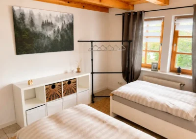 Zweibettzimmer mit Waldmotiv und Holzbalkendecke im Refugium am Ursprung - für eine Auszeit im Schwarzwald